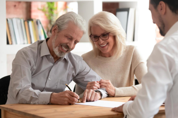 Mature age couple happily signing a document together